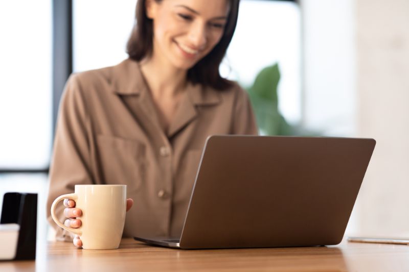 Women stand in front a laptop